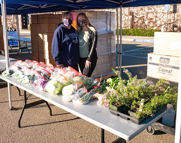 Lisa Bondshu, Hannah Warburton prepare to distribute fresh vegetables
